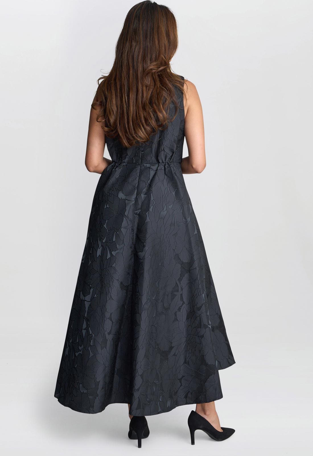 Woman wearing a black patterned dress on a white background