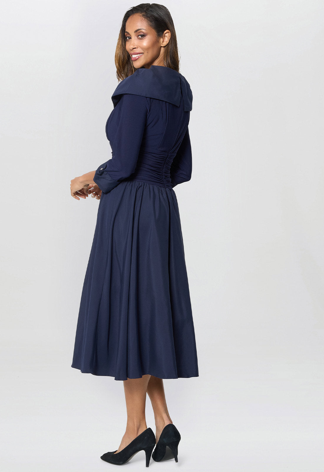 Woman wearing a navy blue dress on a white background