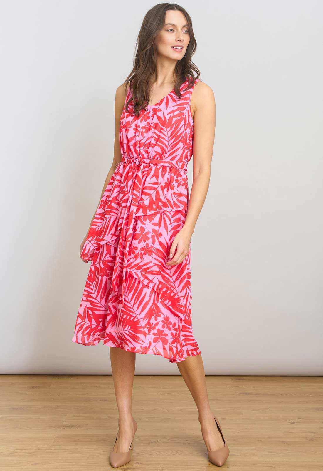 Woman wearing a pink floral dress against a white background