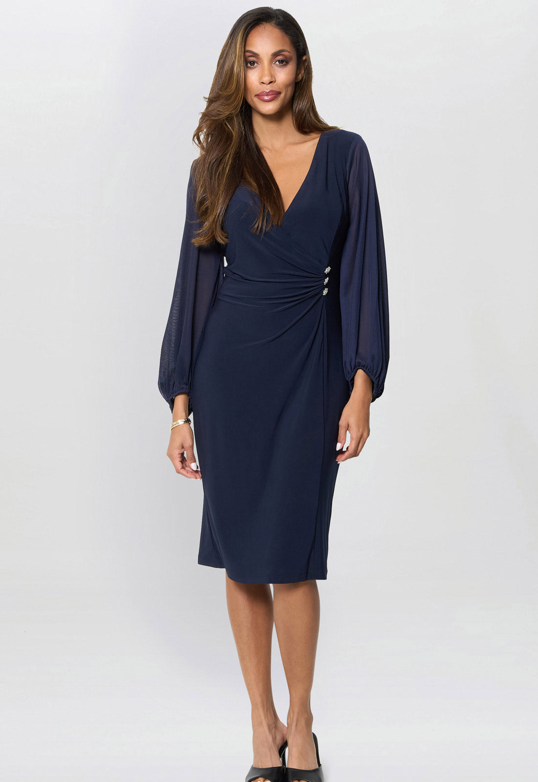Woman wearing a navy blue dress with a plain background
