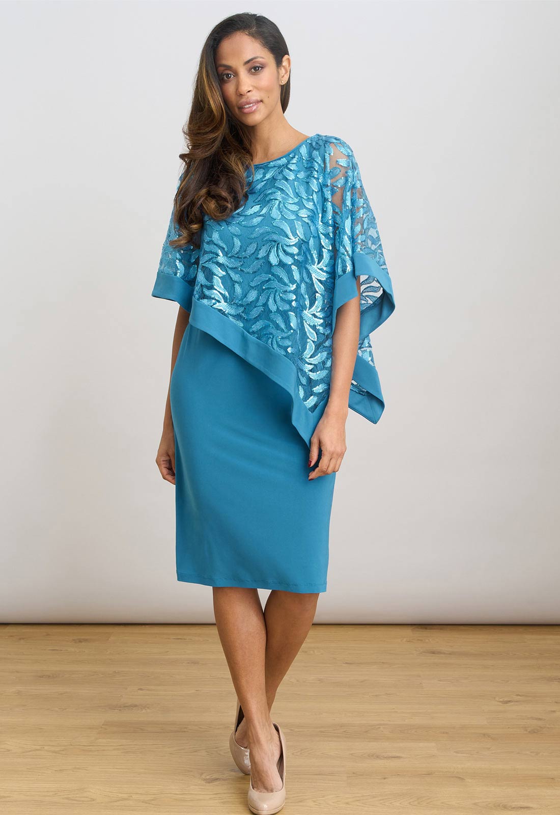 Woman wearing a blue dress with floral patterns on a white background