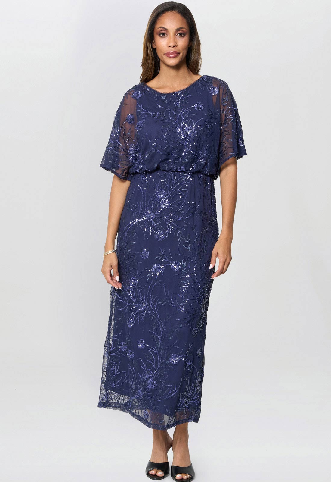 Woman wearing a navy lace dress on a white background