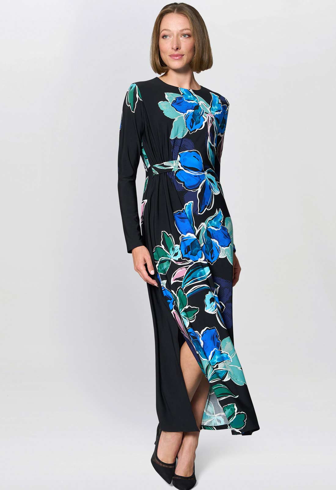 Woman wearing a black dress with blue floral pattern on a white background