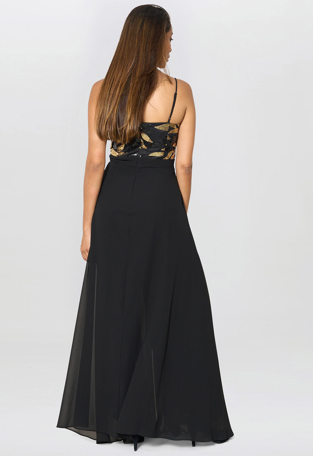 Woman wearing a black dress with floral lace detailing on a white background