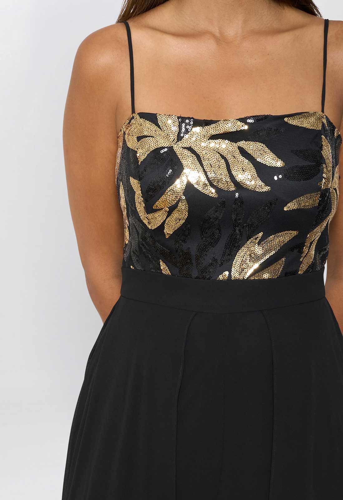 Black dress with gold floral patterns on a plain background