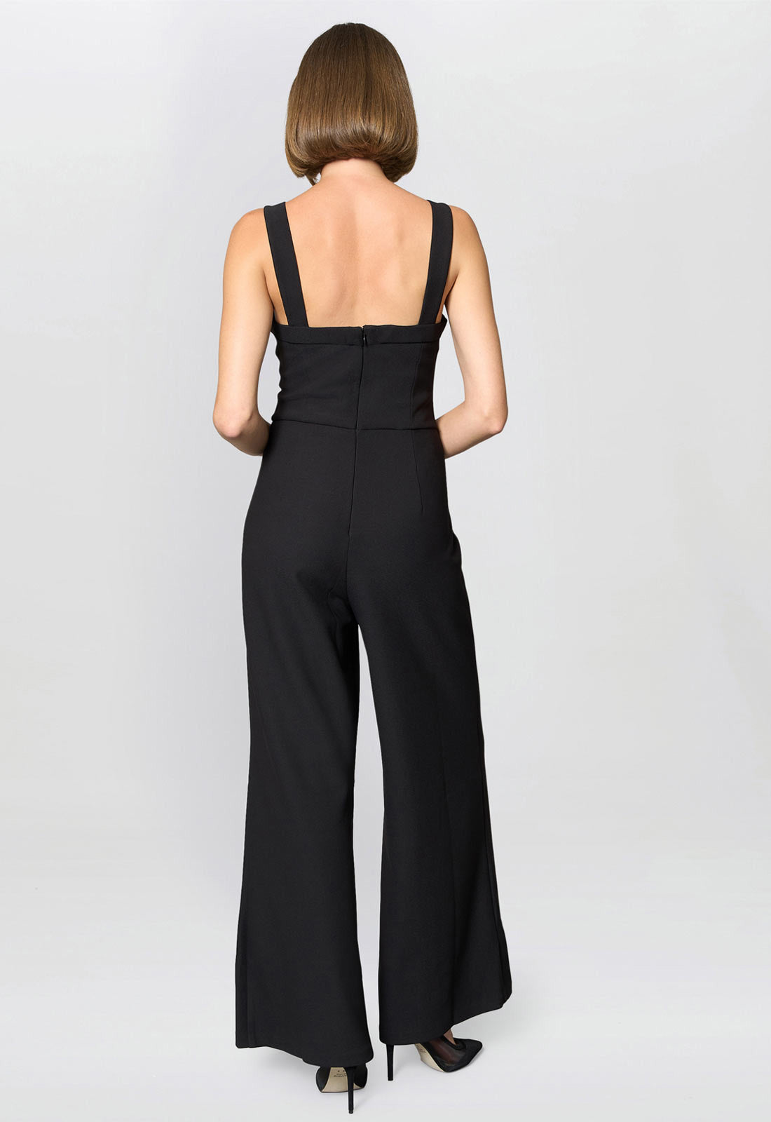 Black jumpsuit worn by a model on a white background