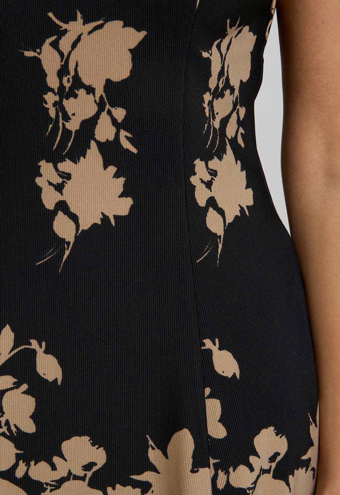Black dress with beige floral pattern on a plain background