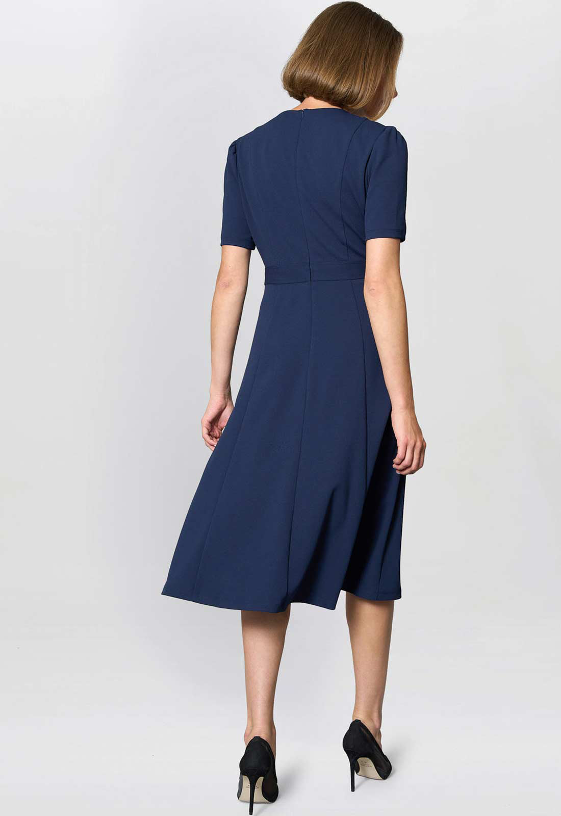 Woman wearing a navy blue dress on a white background