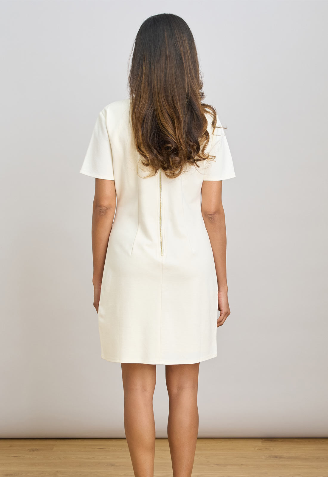 Woman wearing a white dress against a plain background
