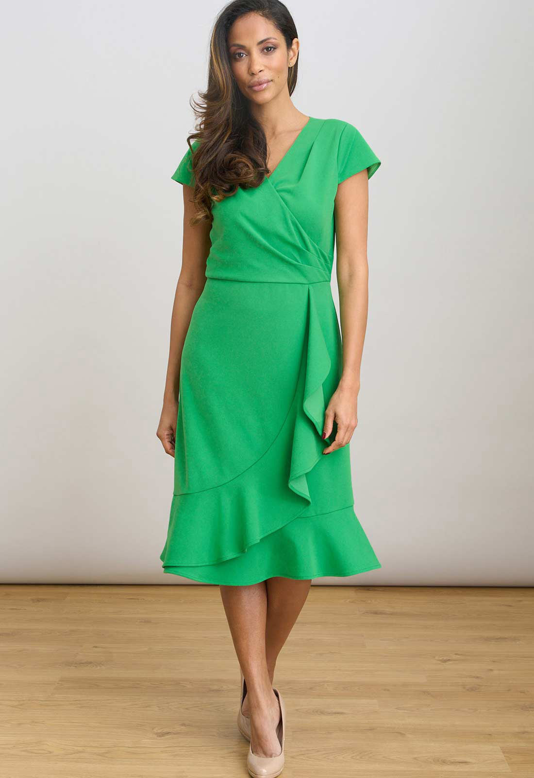 Woman wearing a green dress against a plain background
