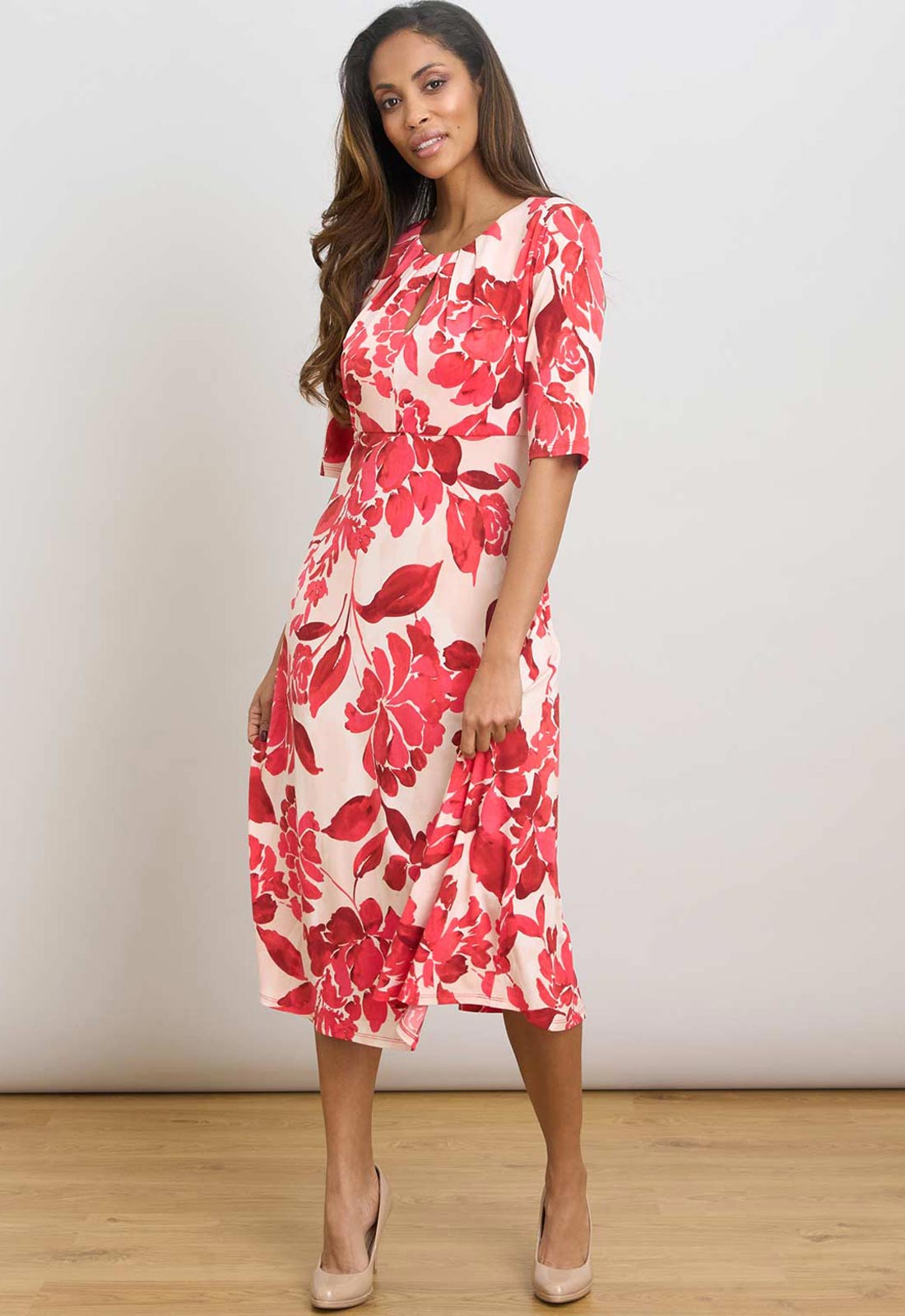 Woman wearing a red floral dress against a white background