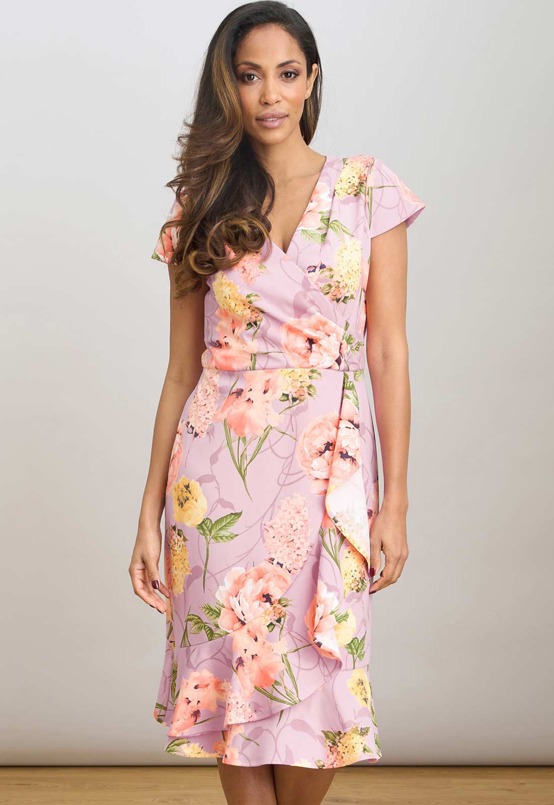 Woman wearing a floral dress against a plain background