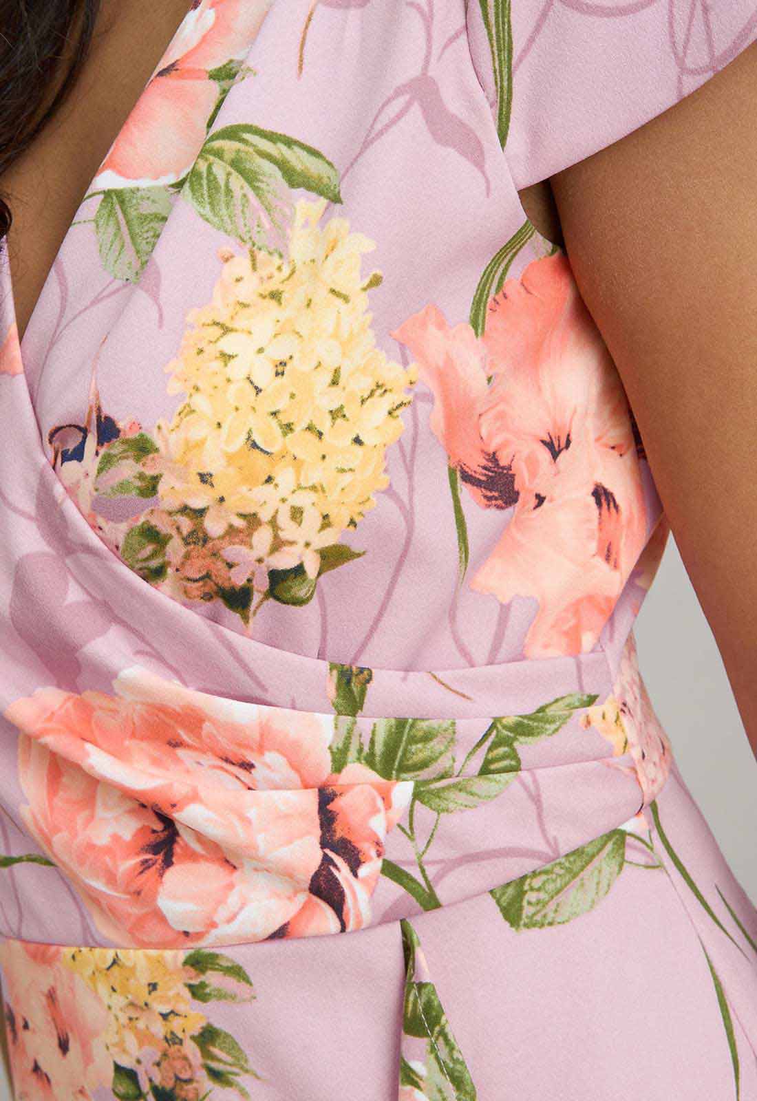 Close-up of a floral dress with pink, yellow, and green colors.