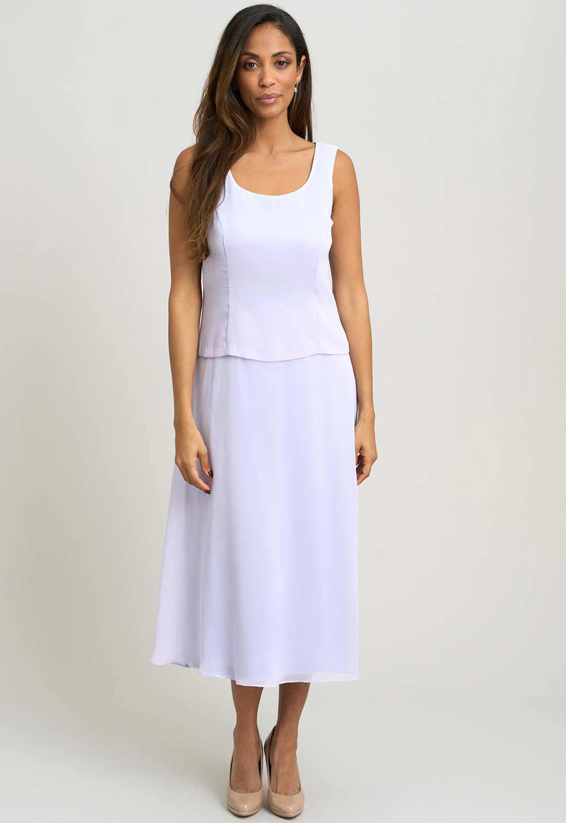 Woman wearing a white sleeveless dress on a plain background