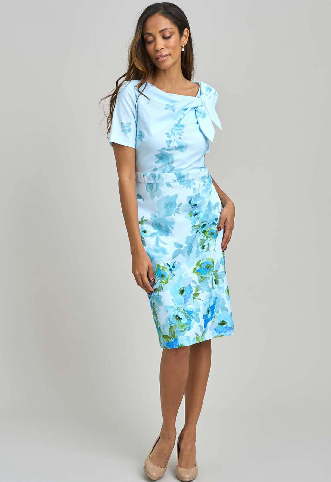 Woman wearing a light blue floral dress against a plain background