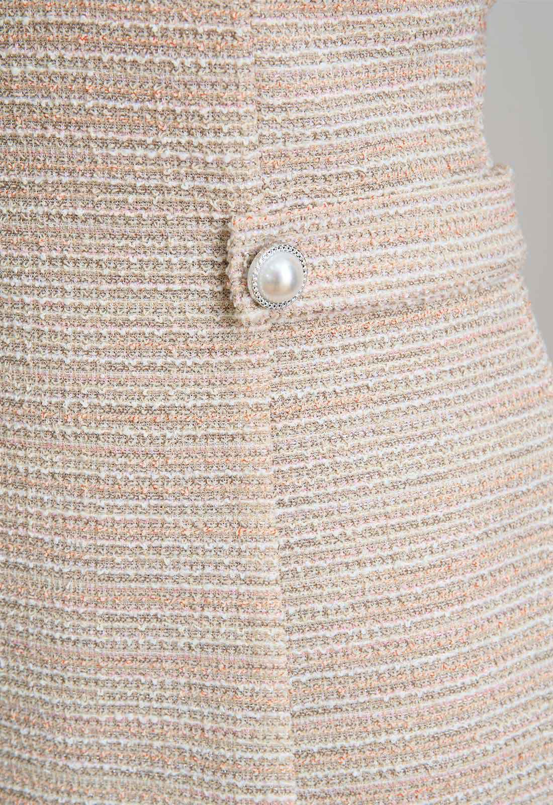Close-up of a textured fabric with a pearl button detail