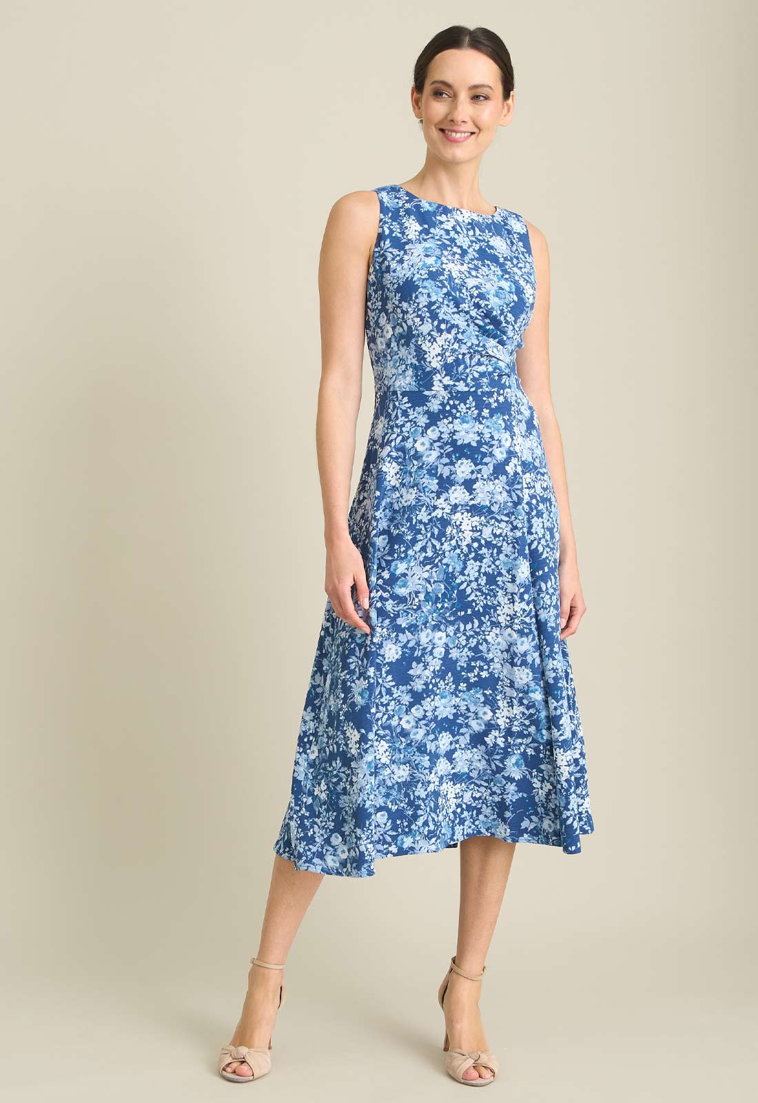 Woman wearing a blue floral dress on a beige background