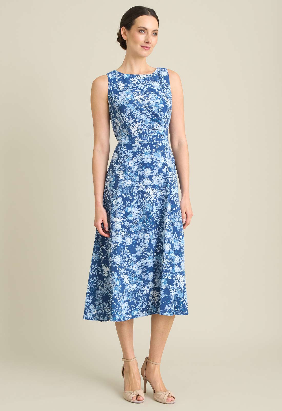 Woman wearing a blue floral dress on a beige background