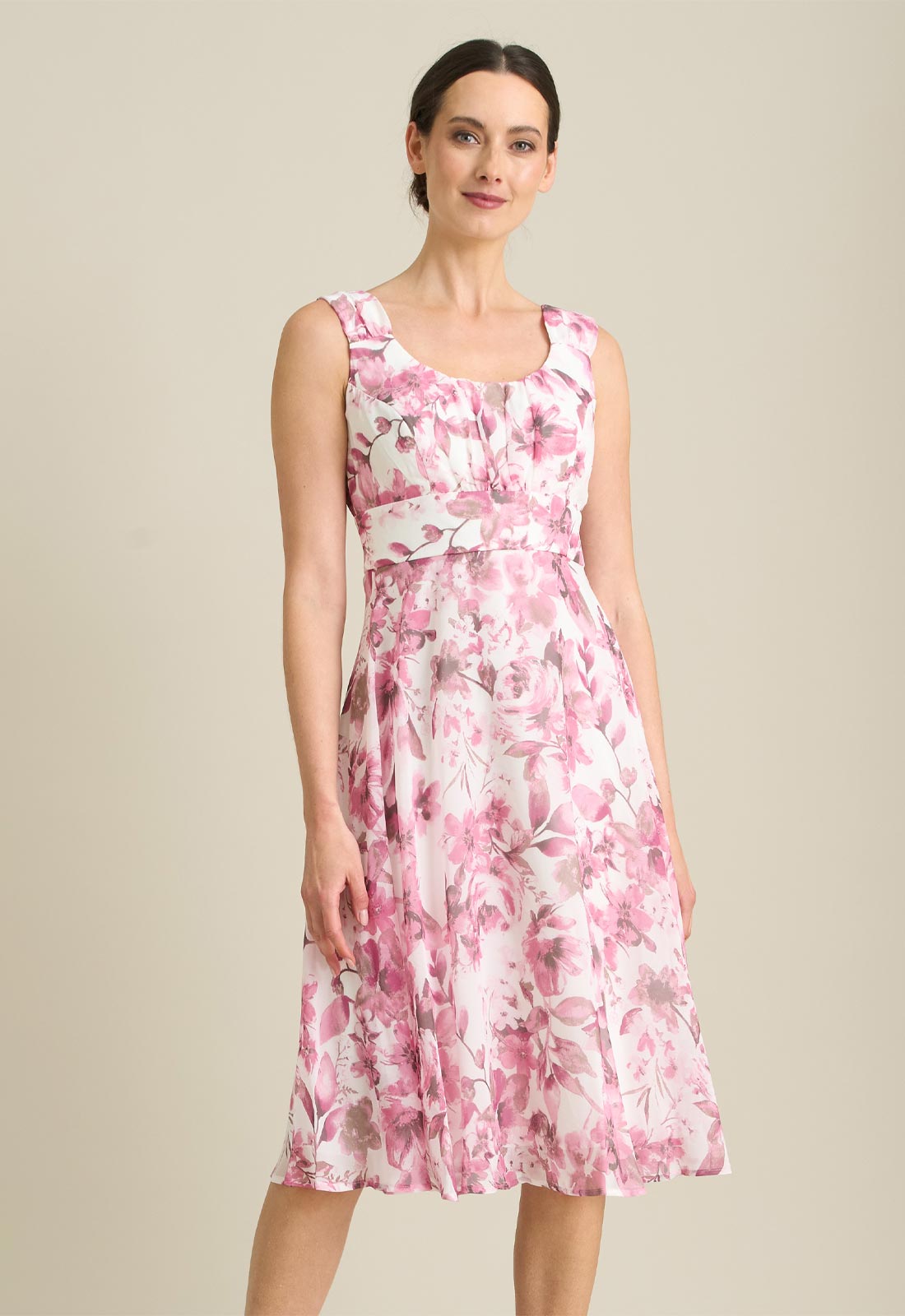 Woman wearing a pink floral dress on a beige background