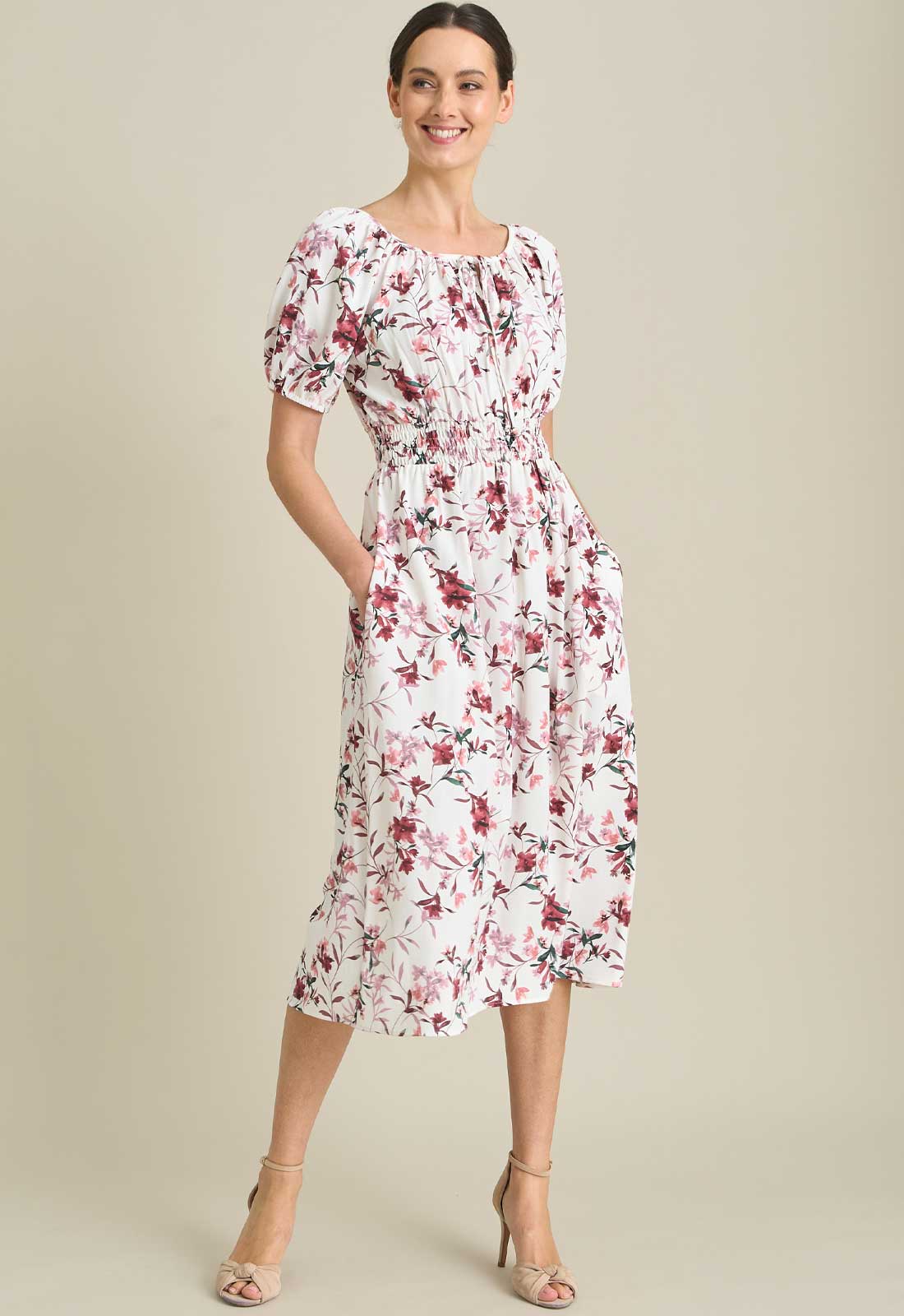 Woman wearing a floral dress on a beige background