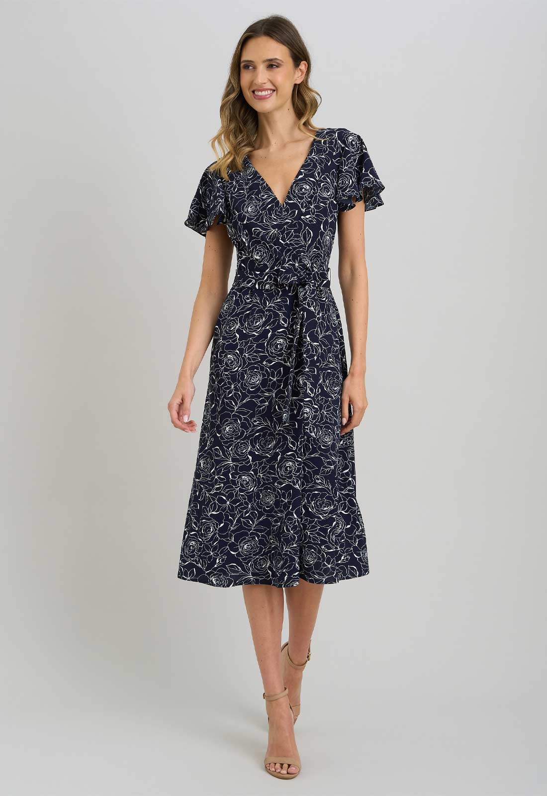 Woman wearing a navy floral dress on a white background