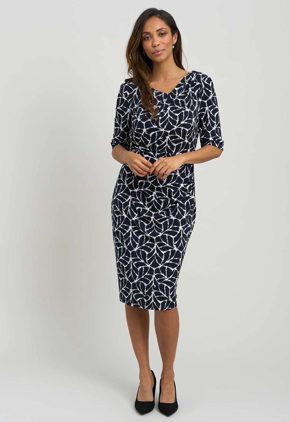Woman wearing a black and white patterned dress on a white background