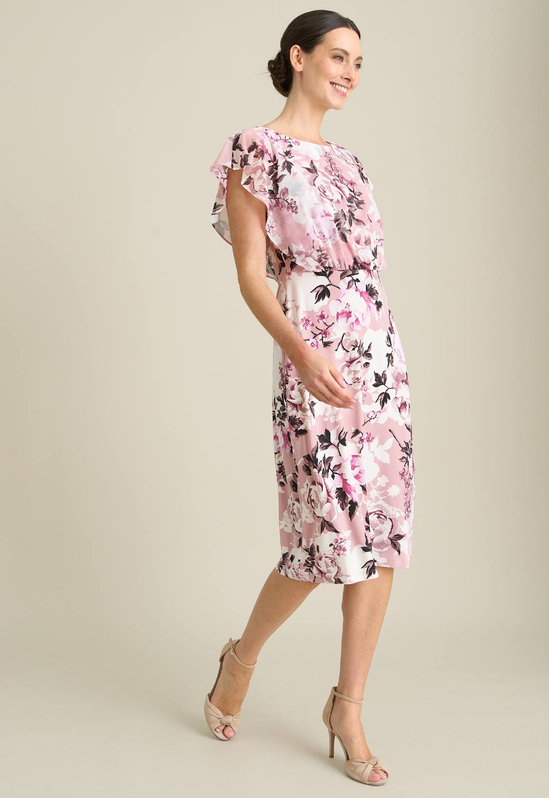Woman wearing a pink floral dress on a beige background