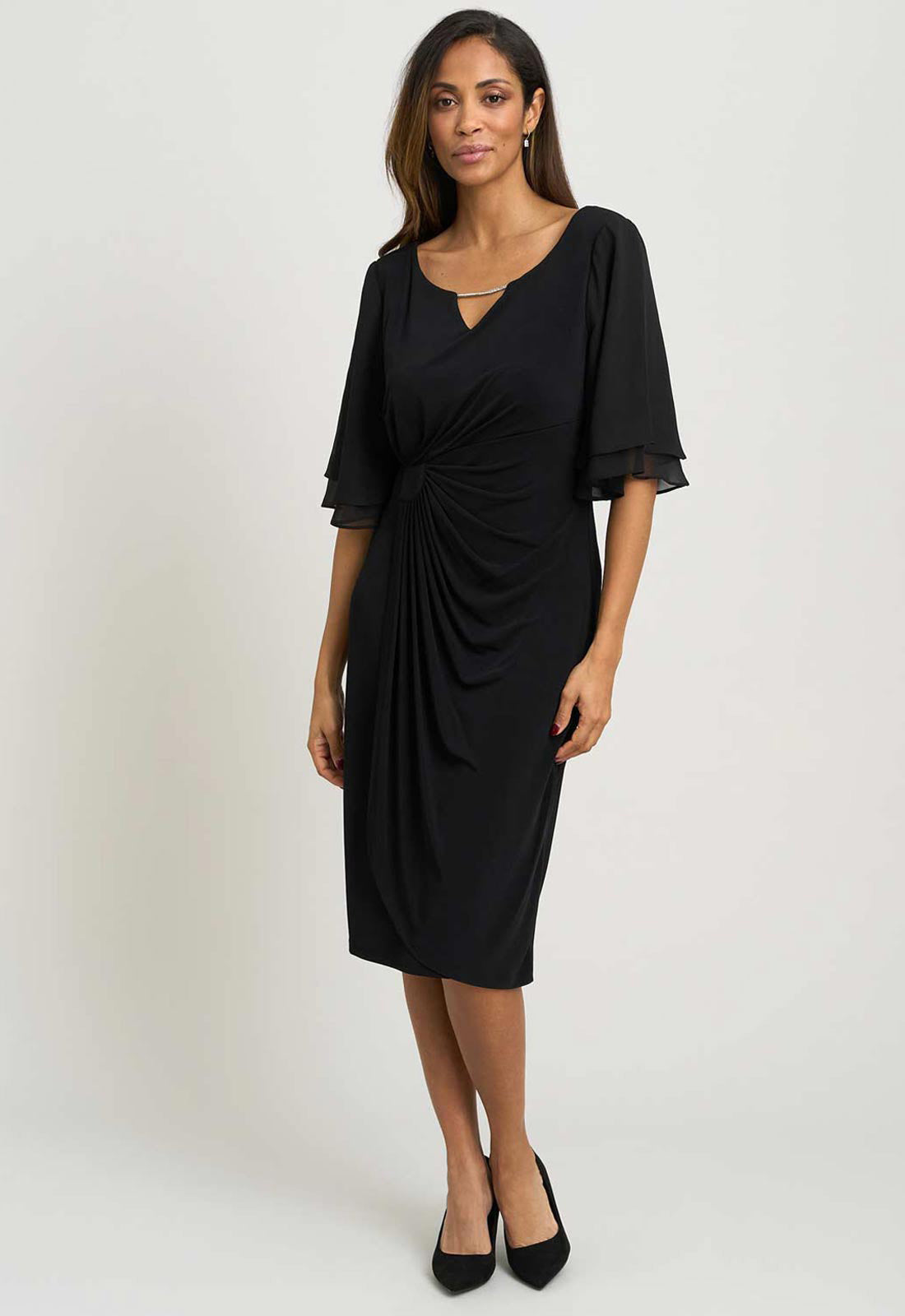 Woman wearing a black dress with a draped front on a white background