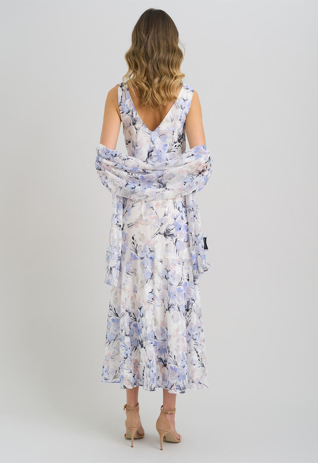 Woman wearing a floral dress with a plain background
