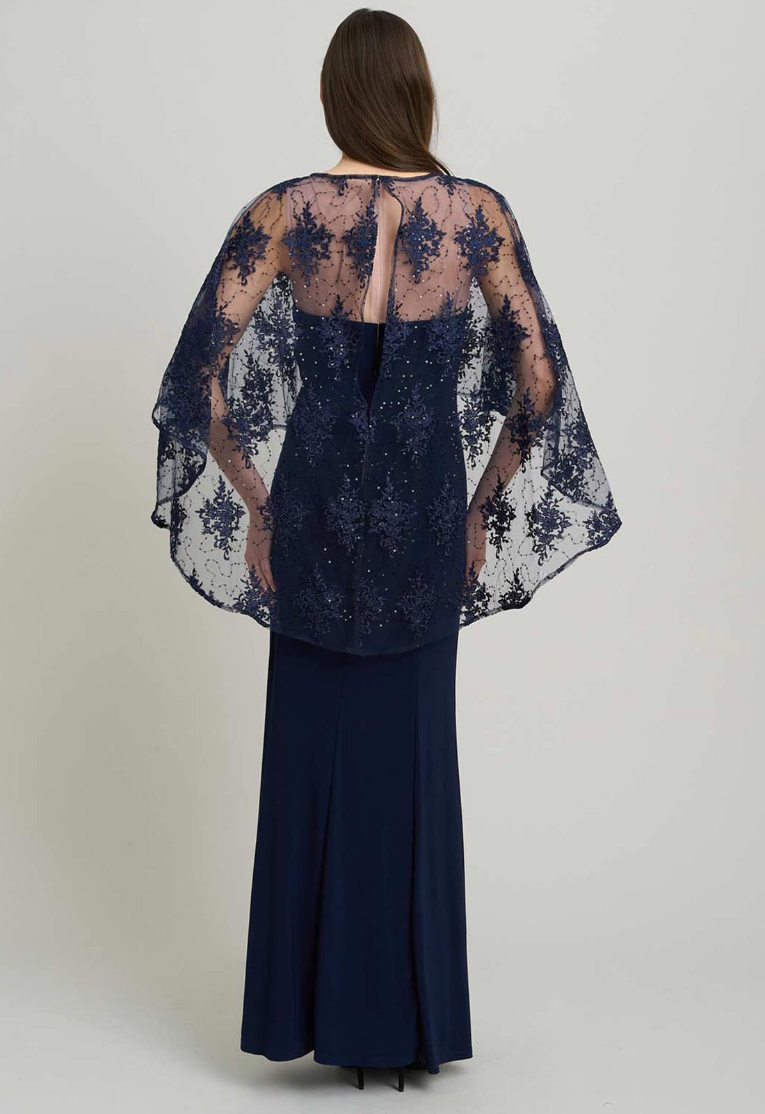 Navy blue lace dress with a matching cape on a plain background