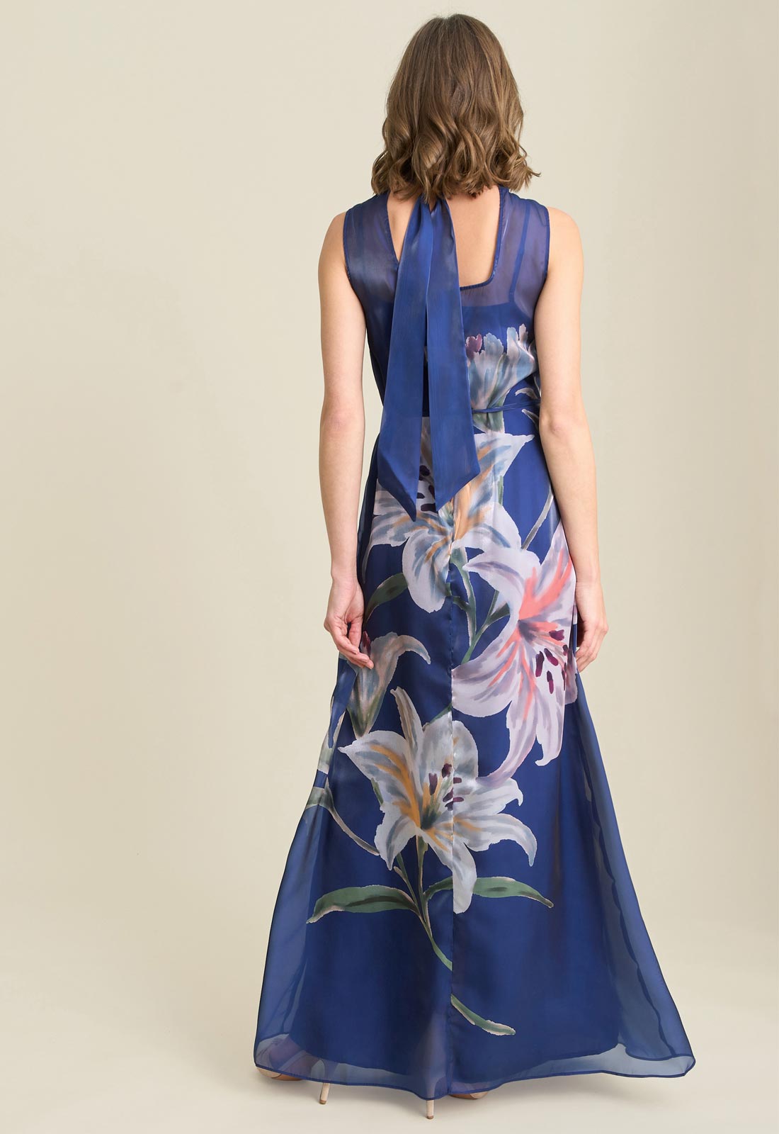 Woman wearing a blue floral dress on a beige background