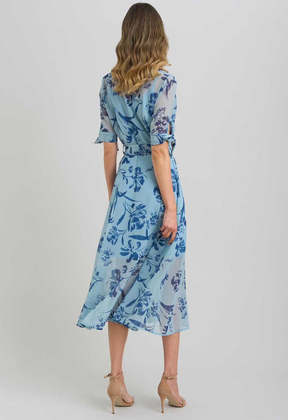 Woman wearing a blue floral dress on a light gray background