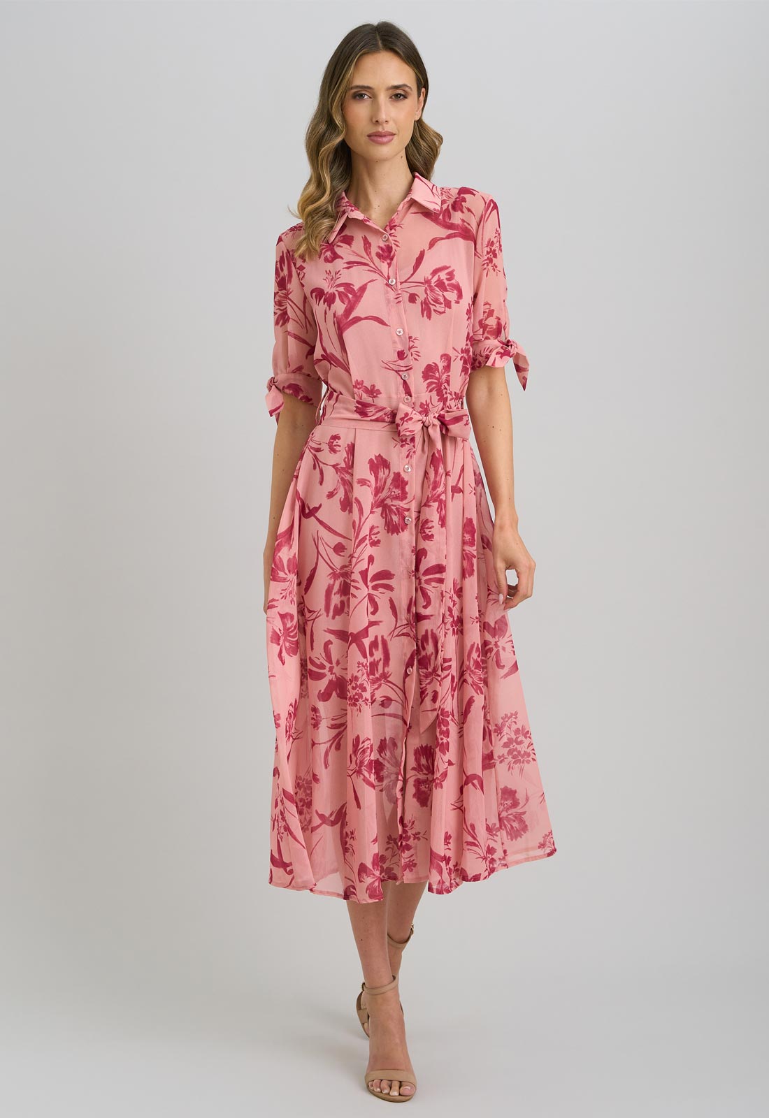 Woman wearing a pink floral dress on a gray background