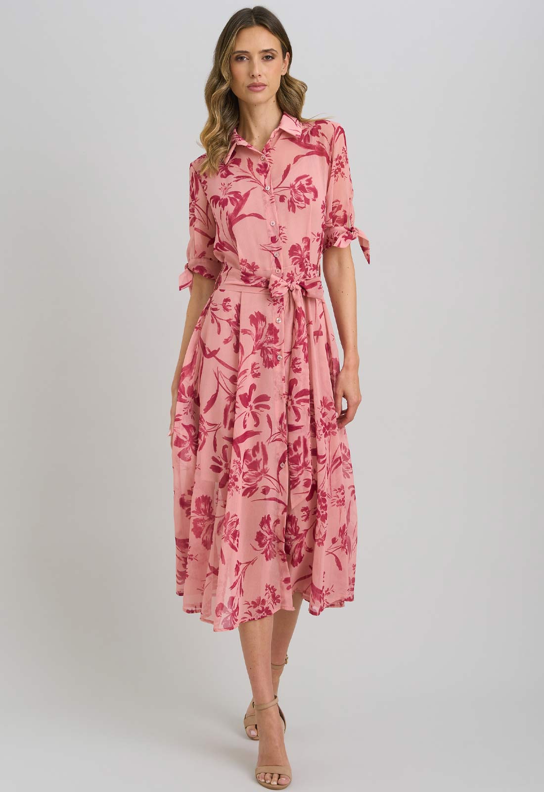 Woman wearing a pink floral dress on a white background