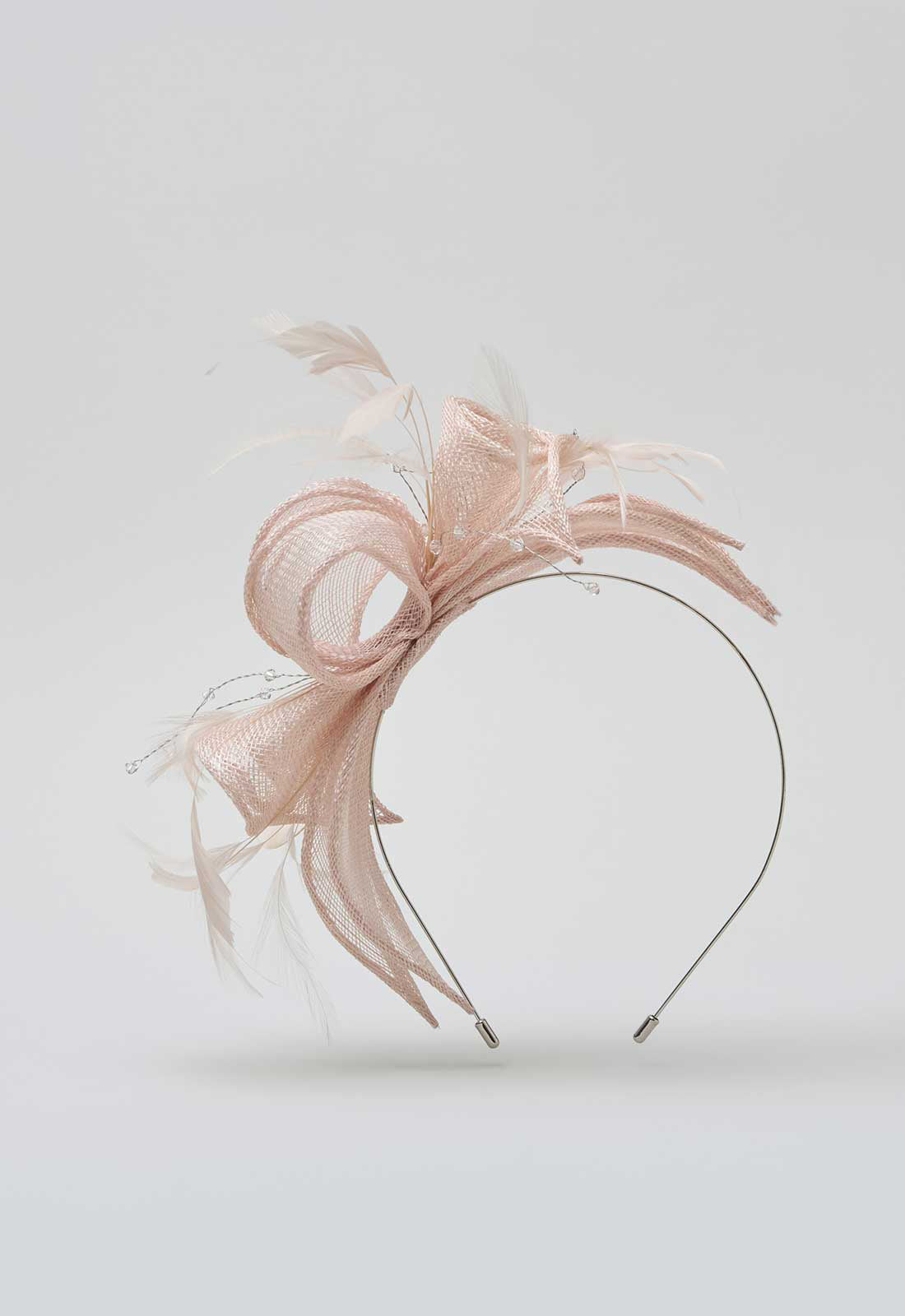 Pink feathered headband on a light gray background