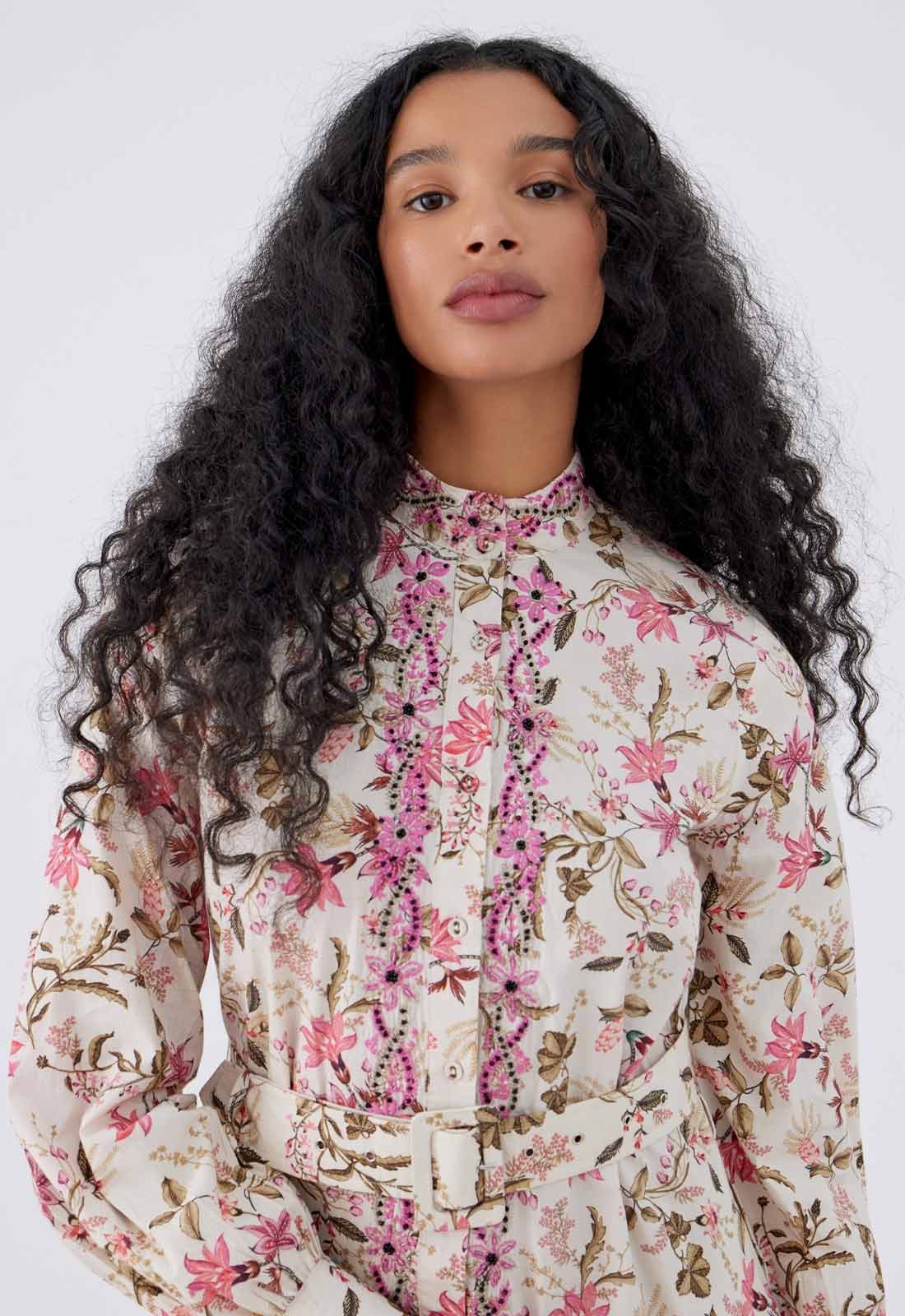 Woman wearing a floral blouse against a white background