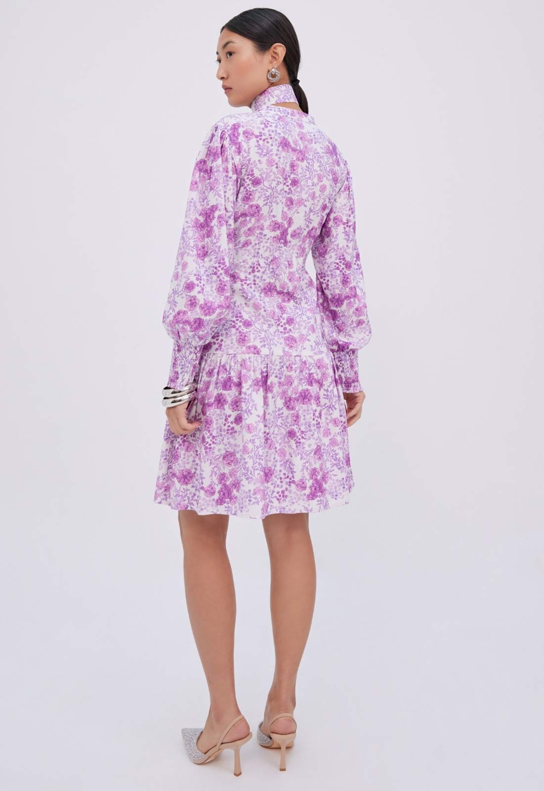 Woman wearing a purple floral dress on a white background