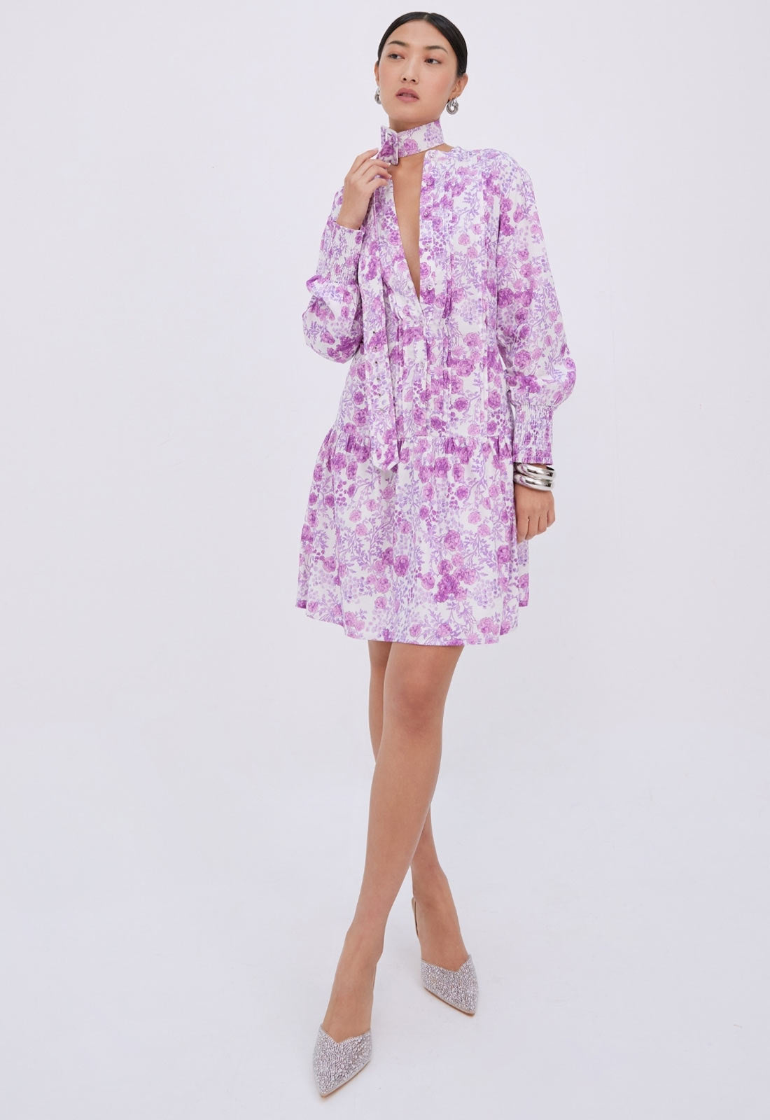Woman wearing a purple floral dress on a white background