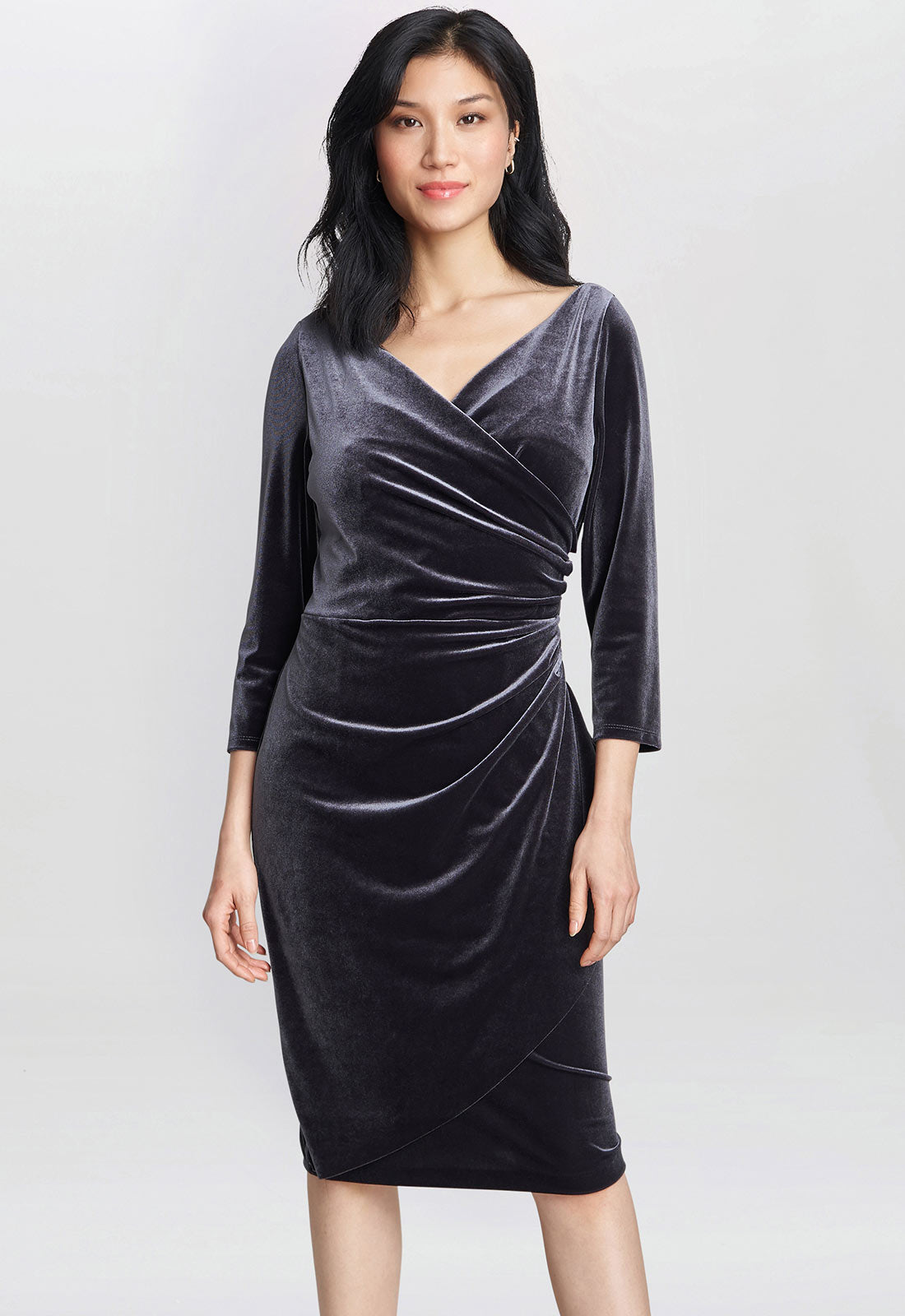 Woman wearing a gray velvet dress on a white background