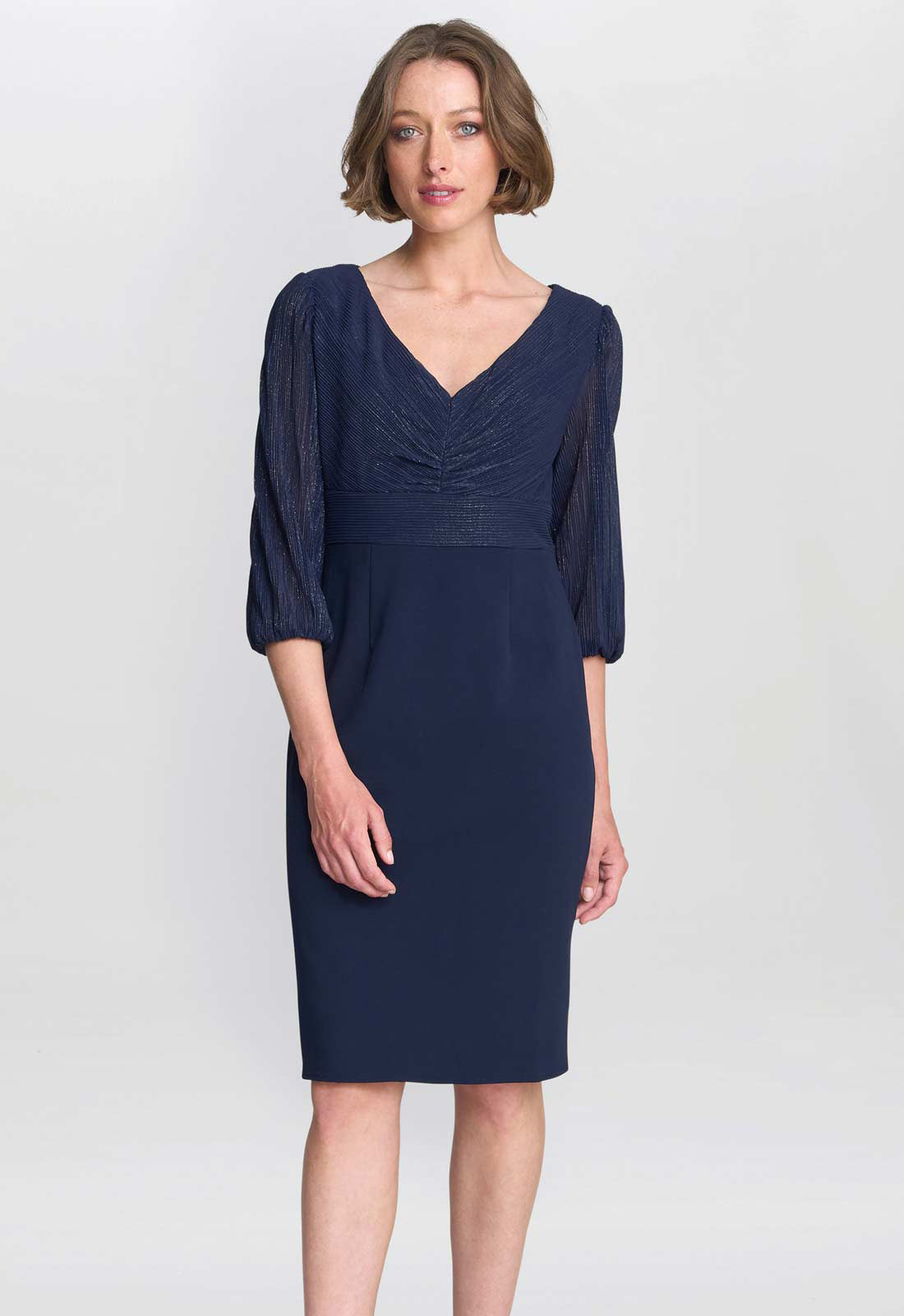 Woman wearing a navy blue dress with a plain background