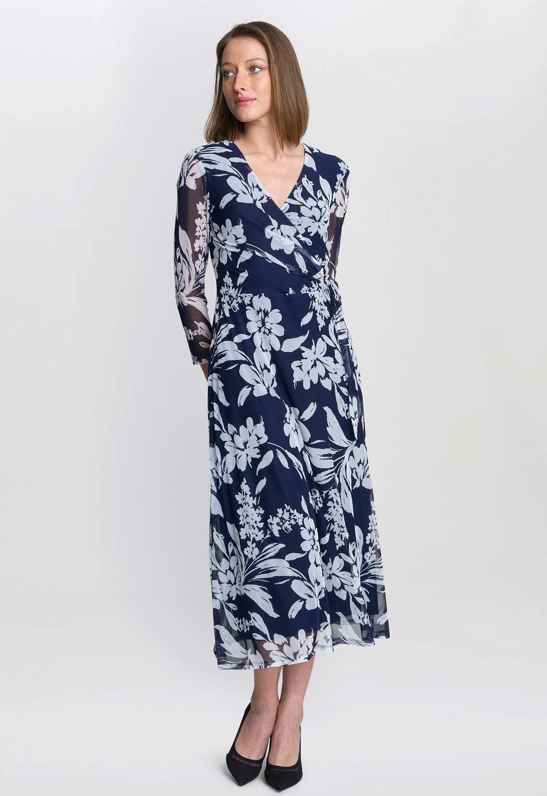Woman wearing a navy floral dress on a white background
