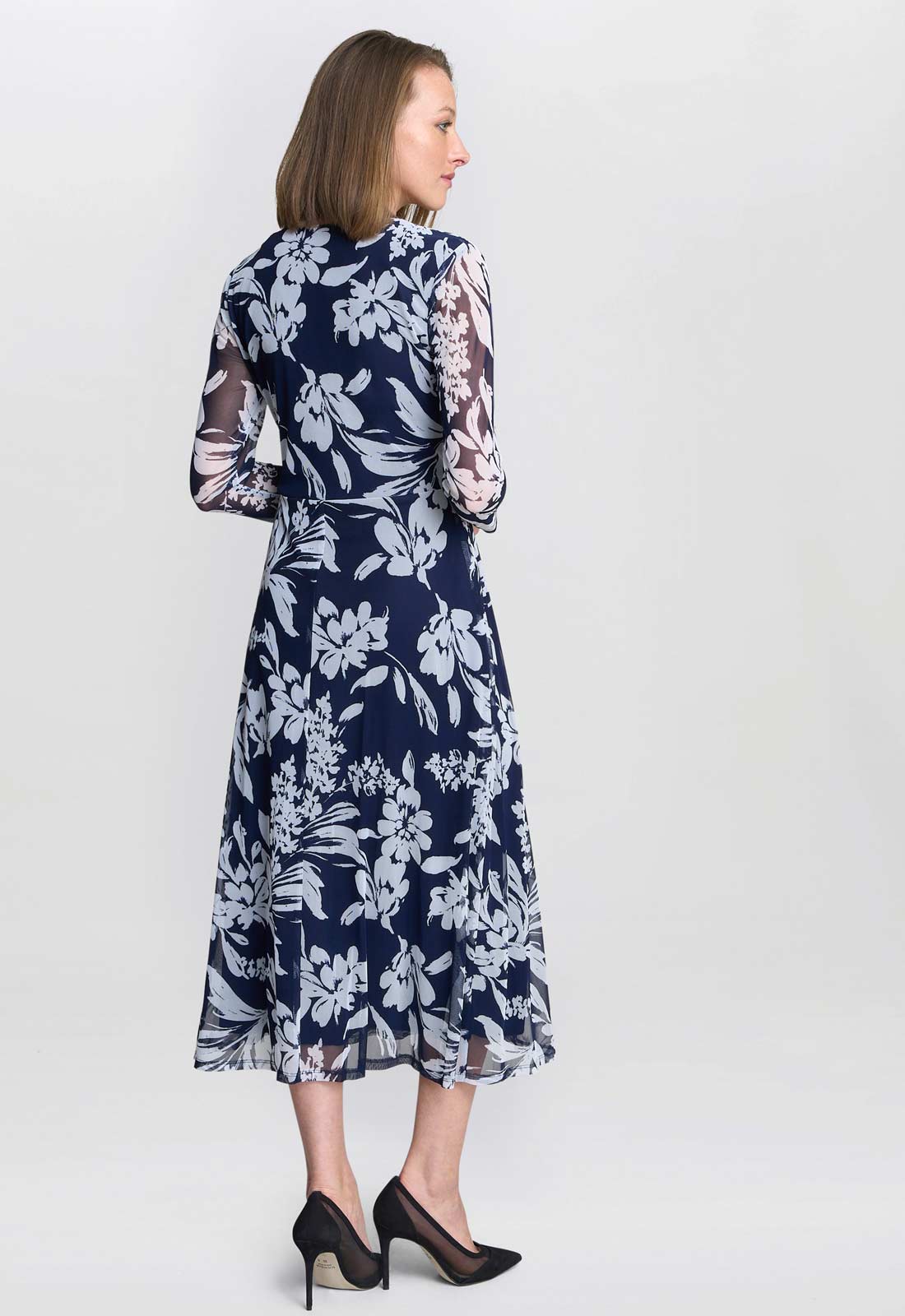 Woman wearing a navy floral dress on a white background