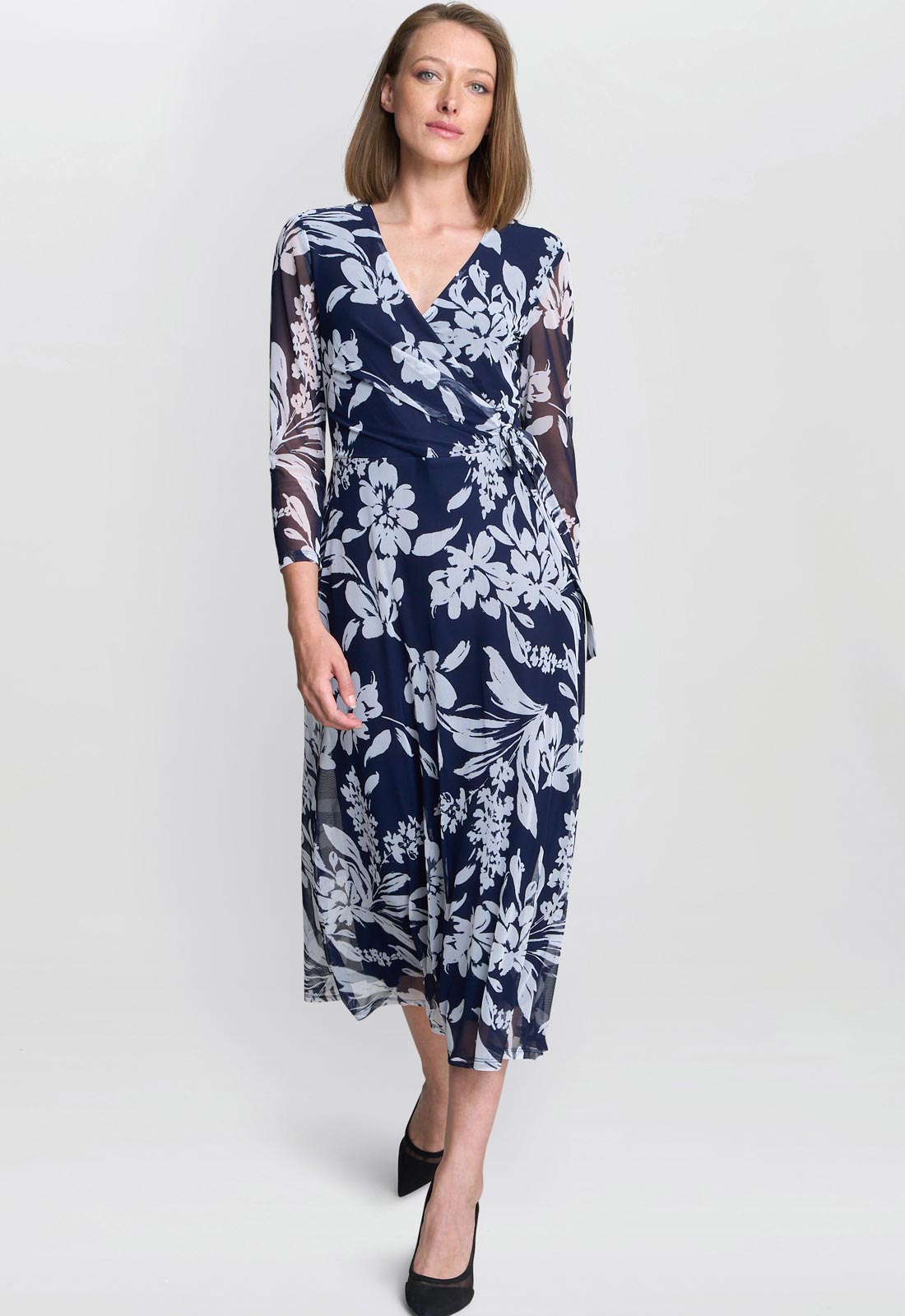Woman wearing a navy floral dress on a white background