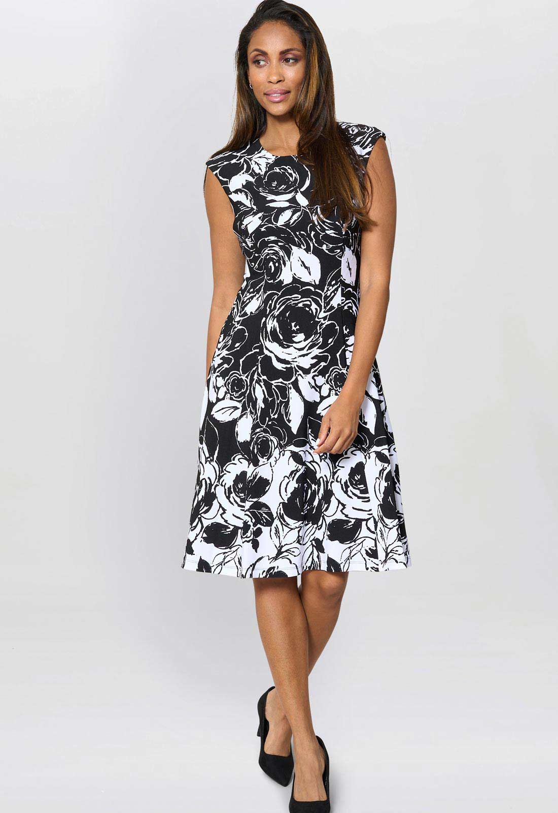 Woman wearing a black and white floral dress on a white background