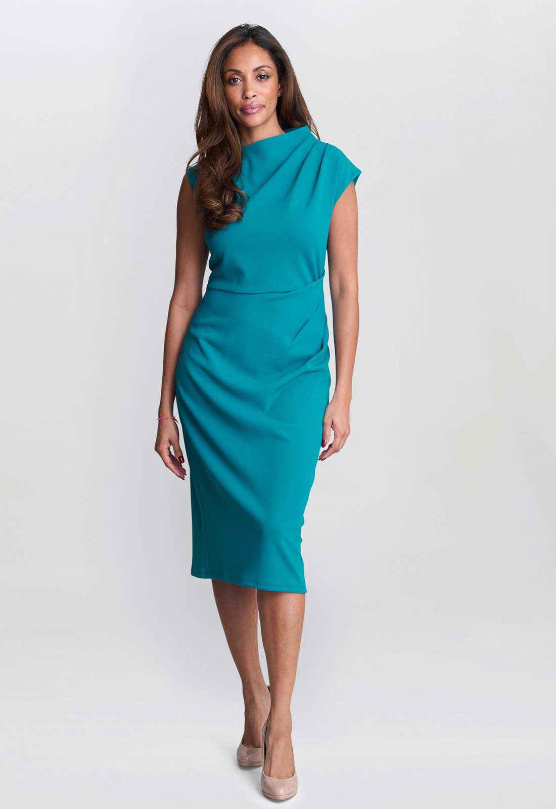 Woman wearing a teal dress on a white background