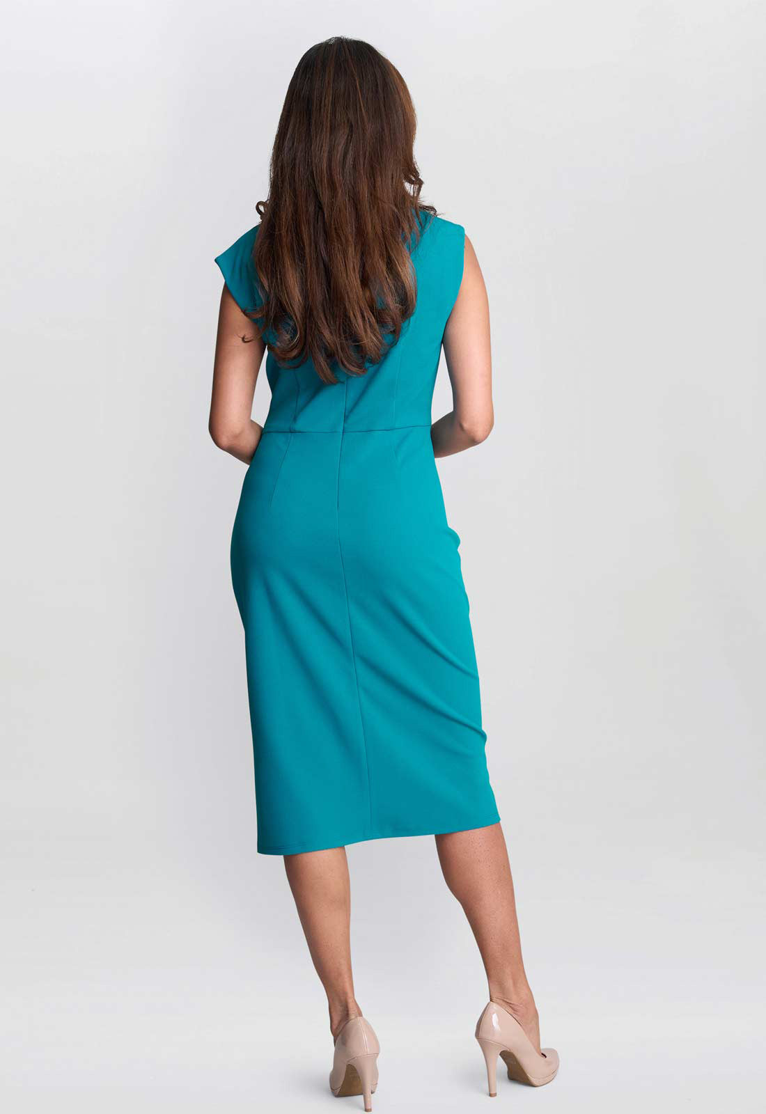 Woman wearing a teal dress on a white background
