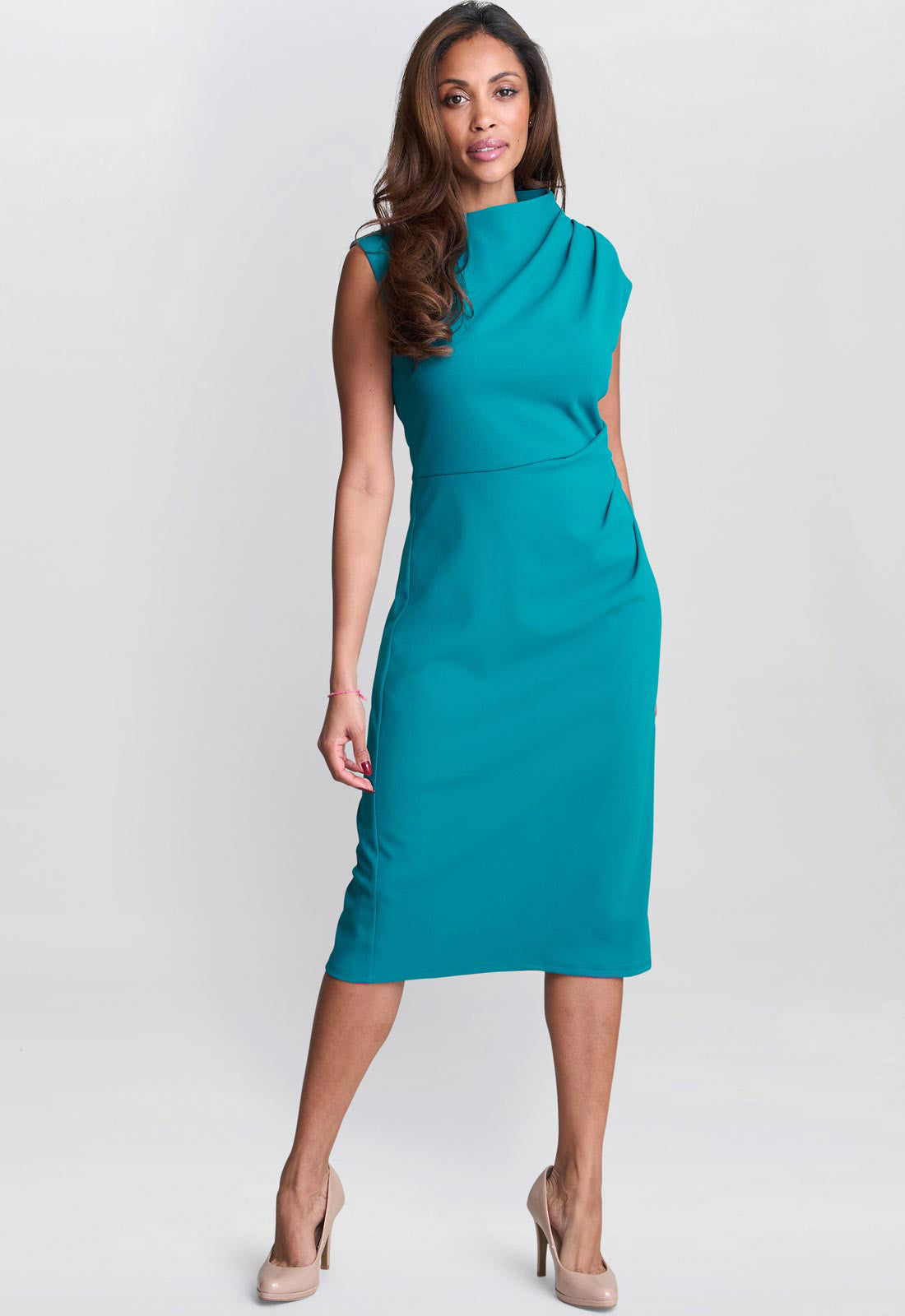 Woman wearing a teal dress on a white background