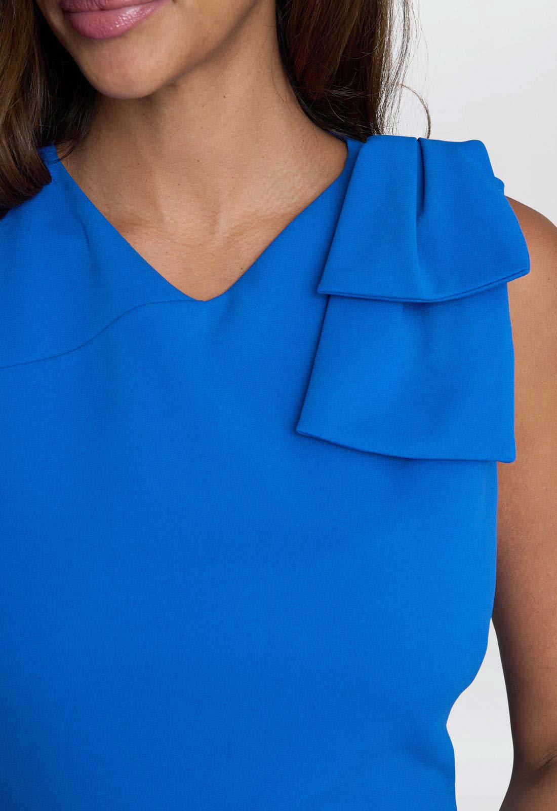 Blue top with ruffled detail on a white background