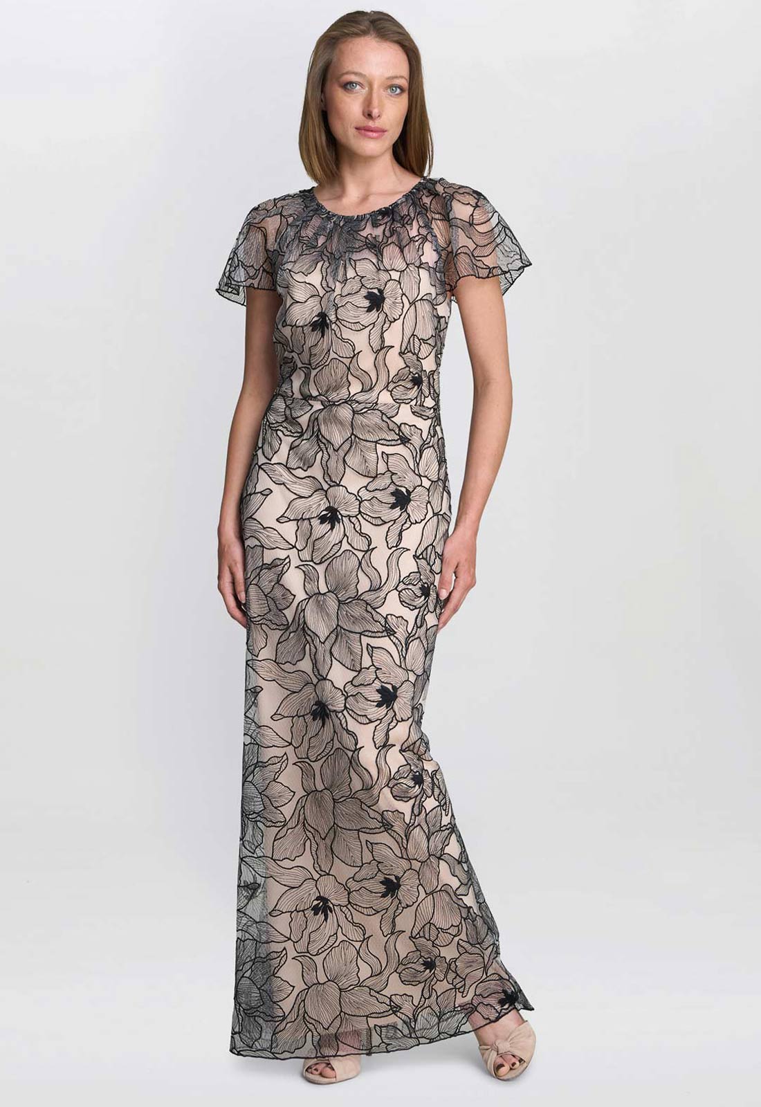 Woman wearing a black floral lace dress on a white background
