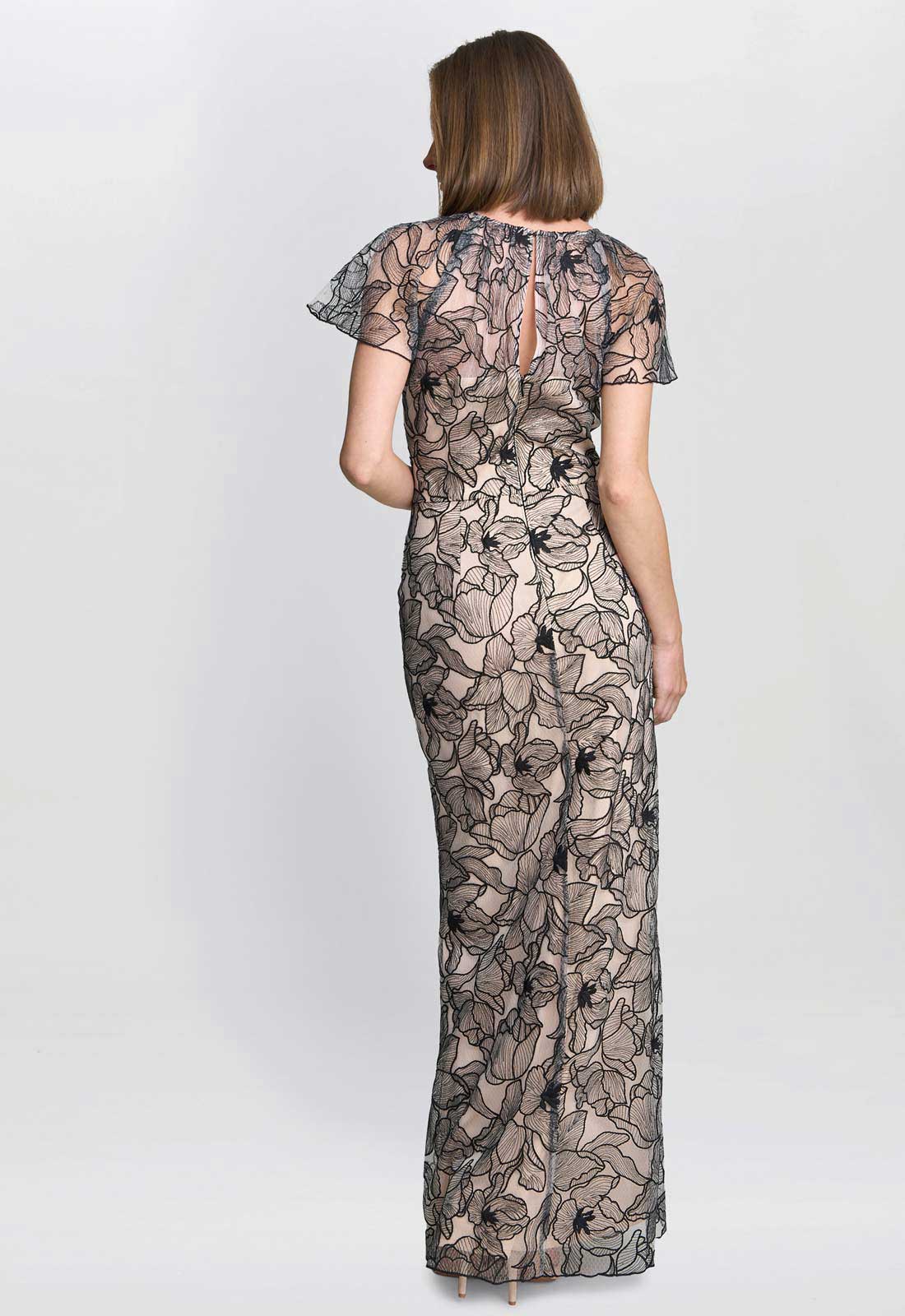 Woman wearing a floral lace jumpsuit on a white background